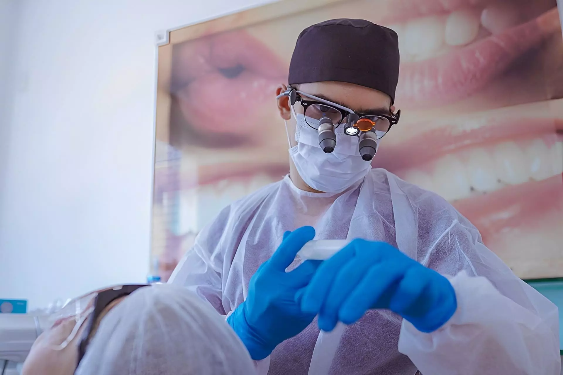 Dentista realizando restauração no dente em consultório odontológico